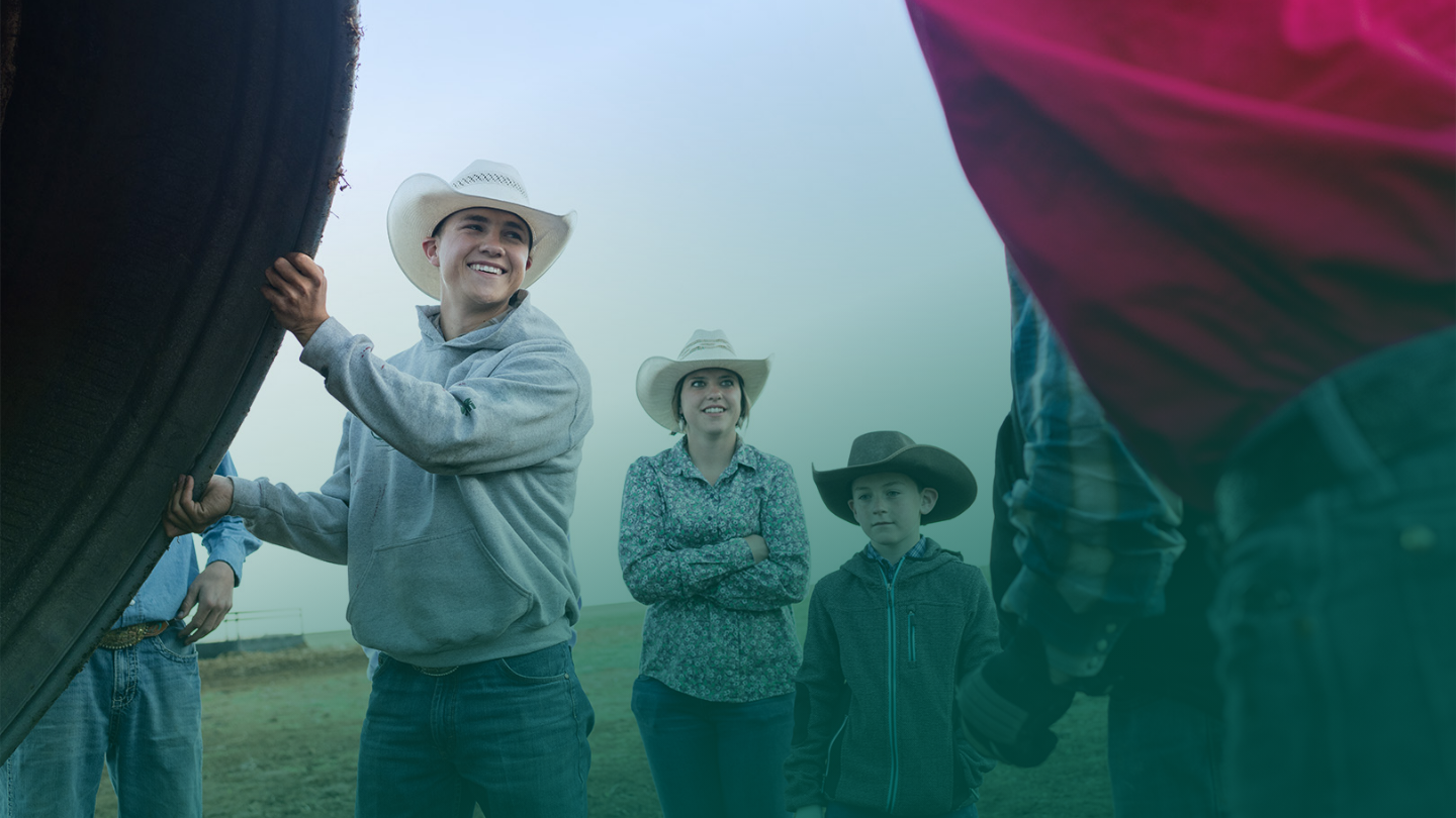 Two young adults and a child wearing cowboy hats, working in a field